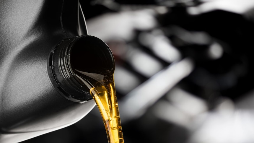 Oil being poured from a bottle into the engine