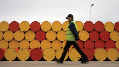 man walking infront of barrels